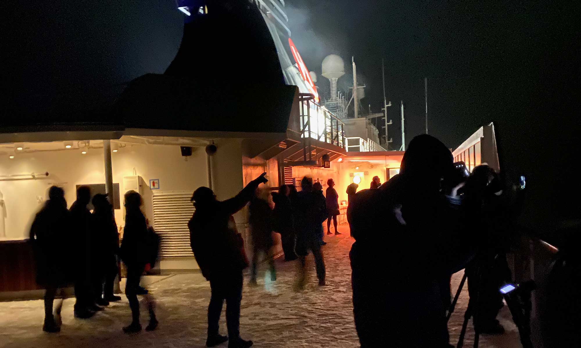 Das Bild zeigt Personen auf der MS Nordnorge, die Polarlichter beobachten