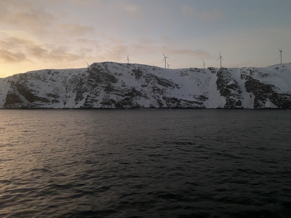 Ausblick von der MS Nordnorge auf das Meer und Küste Windkraftwerk